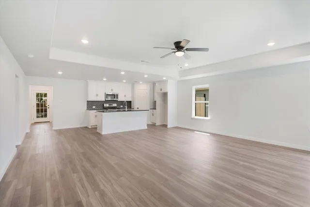a view of a kitchen with a sink and wooden floor