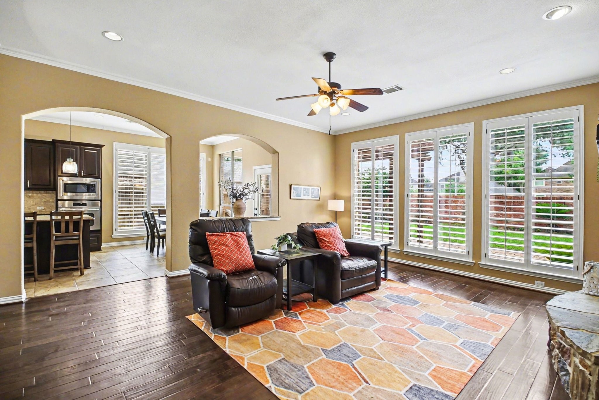8210 Thunder Ridge Way Missouri City, TX 77459 - Photo 13 of 42 Step into the inviting den featuring a seamless kitchen entry and a striking arched window overlooking the breakfast area.