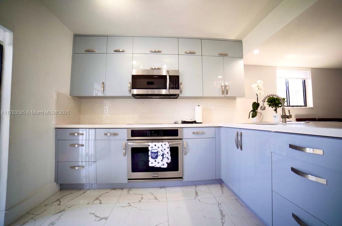 1380 West 41st Street, Unit 101 Hialeah, FL 33012 - Photo 11 of 23 a kitchen with stainless steel appliances granite countertop a stove a microwave and a sink