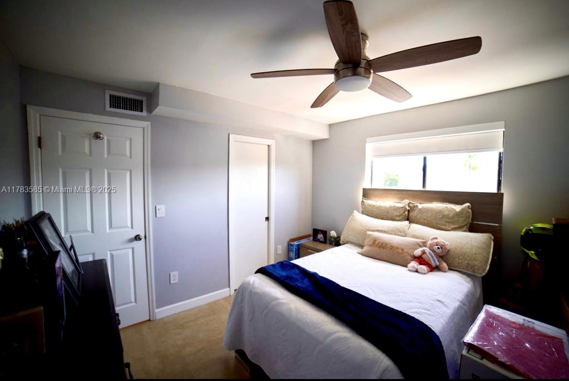 1380 West 41st Street, Unit 101 Hialeah, FL 33012 - Photo 19 of 23 a bedroom with a bed and a chandelier