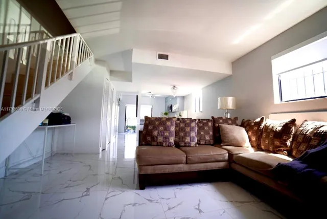 a living room with furniture and stairs