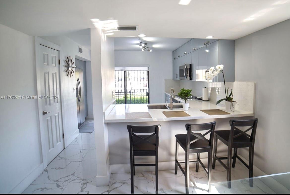1380 West 41st Street, Unit 101 Hialeah, FL 33012 - Photo 7 of 23 a kitchen with a table and chairs in it