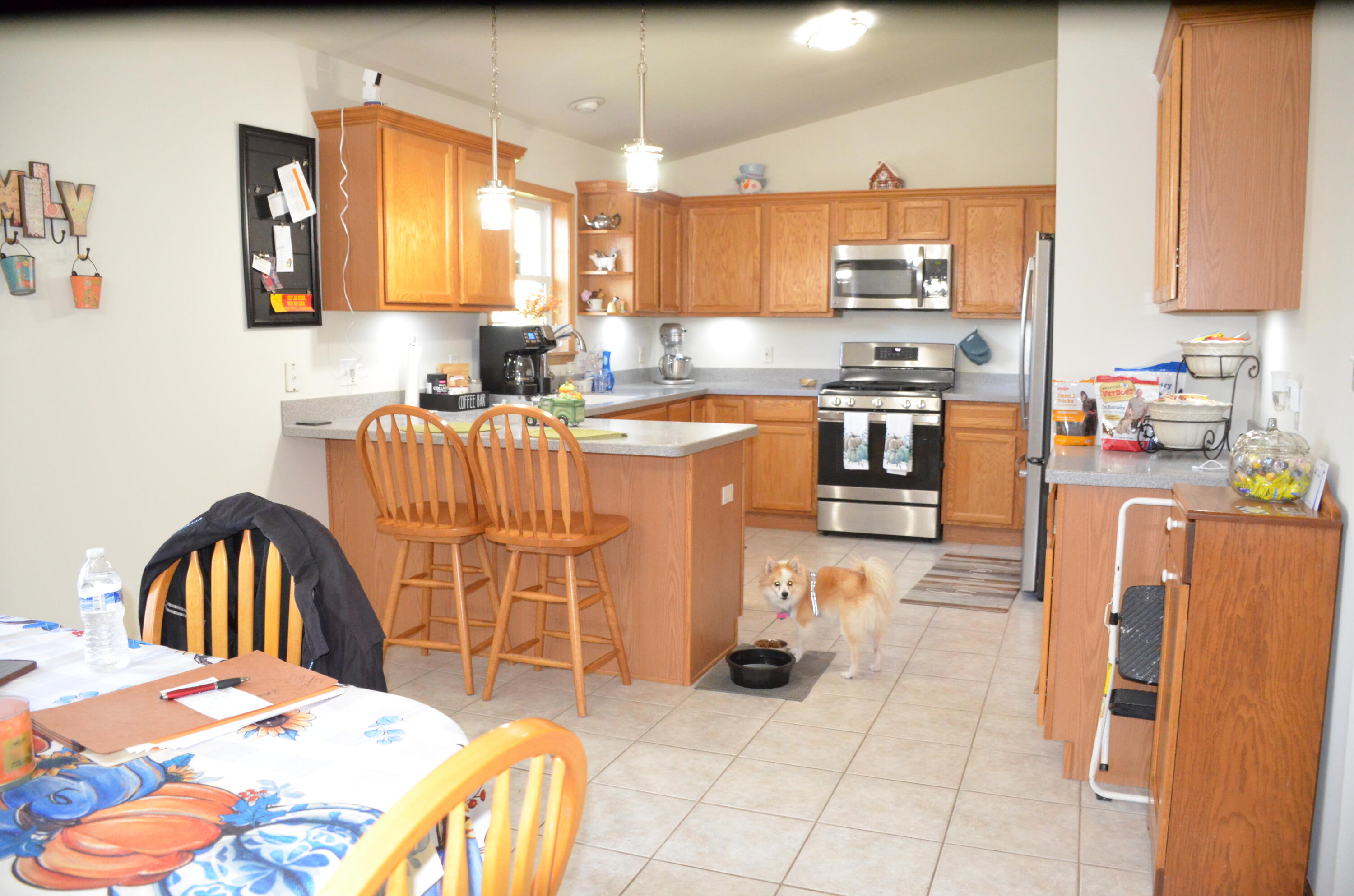 8262 Heron Lake Road St. John, IN 46373 - Photo 39 of 51 a kitchen with stainless steel appliances kitchen island granite countertop a refrigerator a stove a sink dishwasher and white cabinets with wooden floor