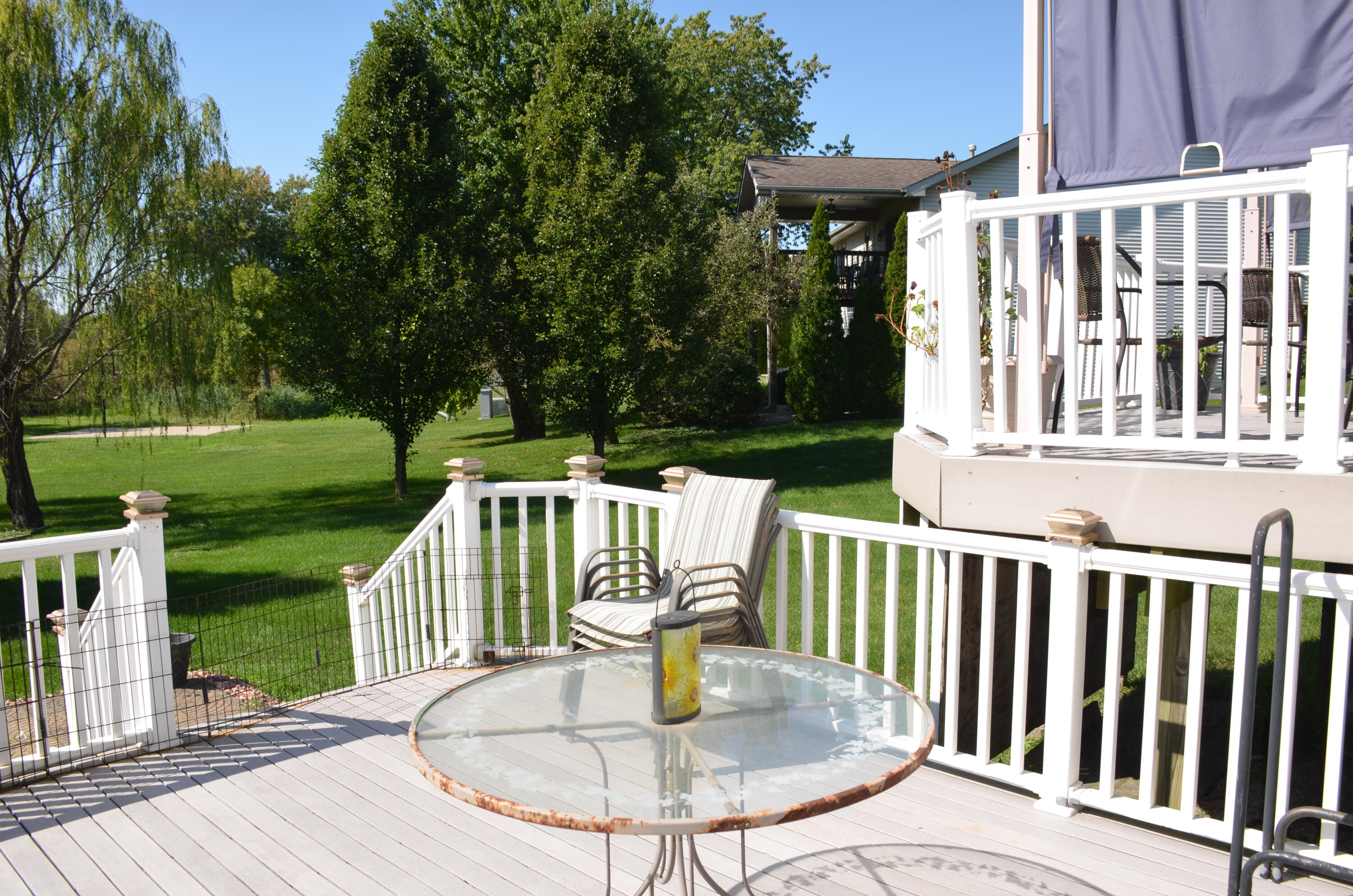 8262 Heron Lake Road St. John, IN 46373 - Photo 7 of 51 a view of a deck with a table and chairs a wooden floor and fence