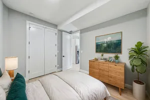 a bedroom with a bed and a potted plant