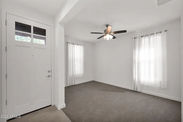 an empty room with closet and windows