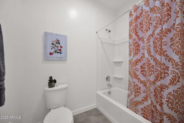 a white toilet sitting next to a bath tub