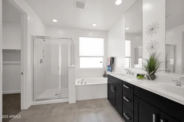 a spacious bathroom with a granite countertop sink mirror and a bathtub