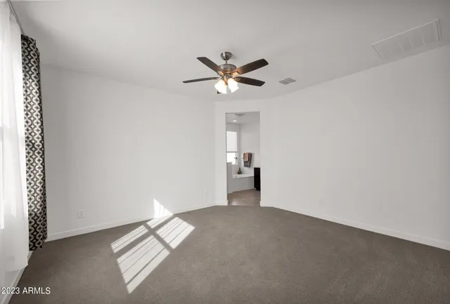 a view of a room with a ceiling fan and window