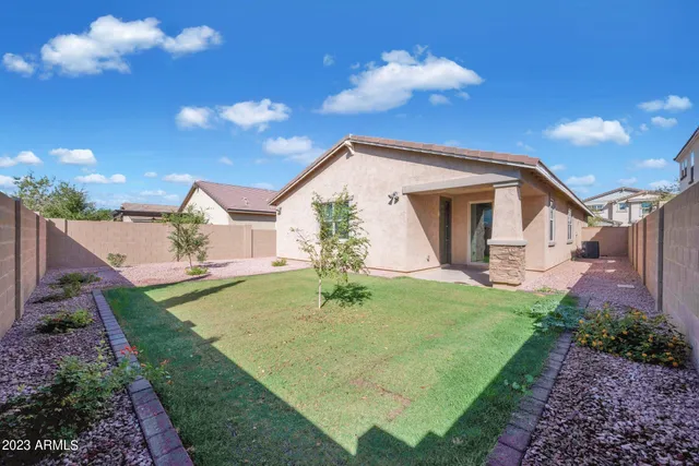 a backyard of a house with table and chairs