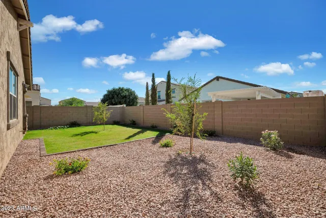 a backyard of a house with a yard and outdoor seating