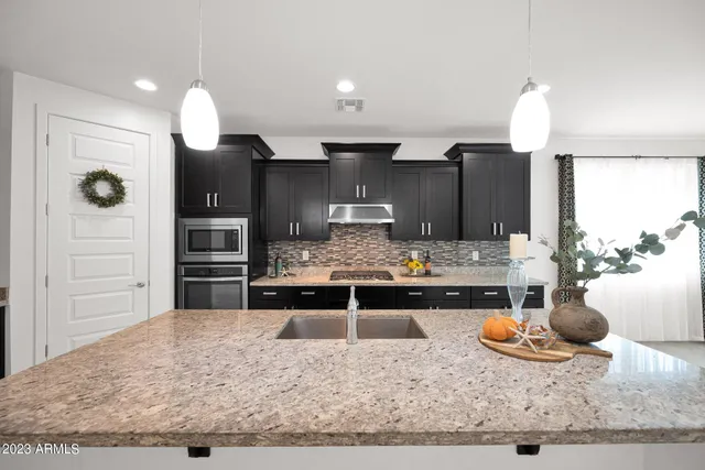 a kitchen with kitchen island granite countertop wooden cabinets and a sink