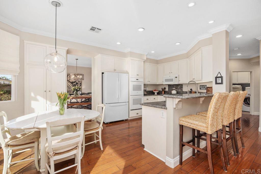 6707 Blue Point Drive Carlsbad, CA 92011 - Photo 16 of 43 a kitchen with white cabinets and stainless steel appliances