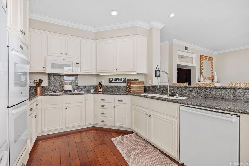 6707 Blue Point Drive Carlsbad, CA 92011 - Photo 17 of 43 a kitchen with granite countertop white cabinets and white appliances