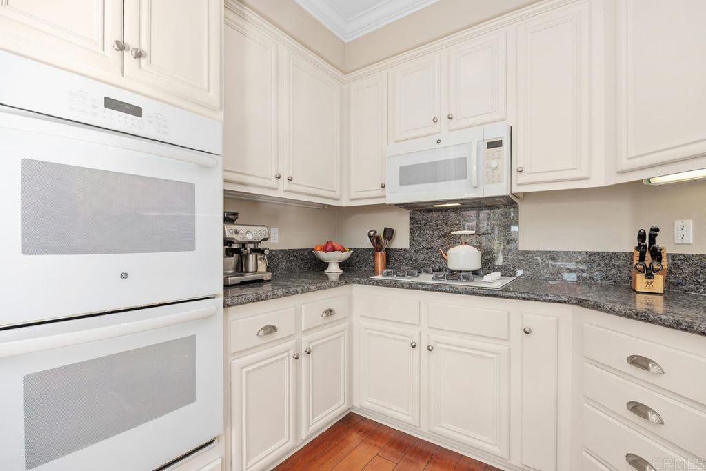 6707 Blue Point Drive Carlsbad, CA 92011 - Photo 18 of 43 a kitchen with granite countertop white cabinets and white appliances