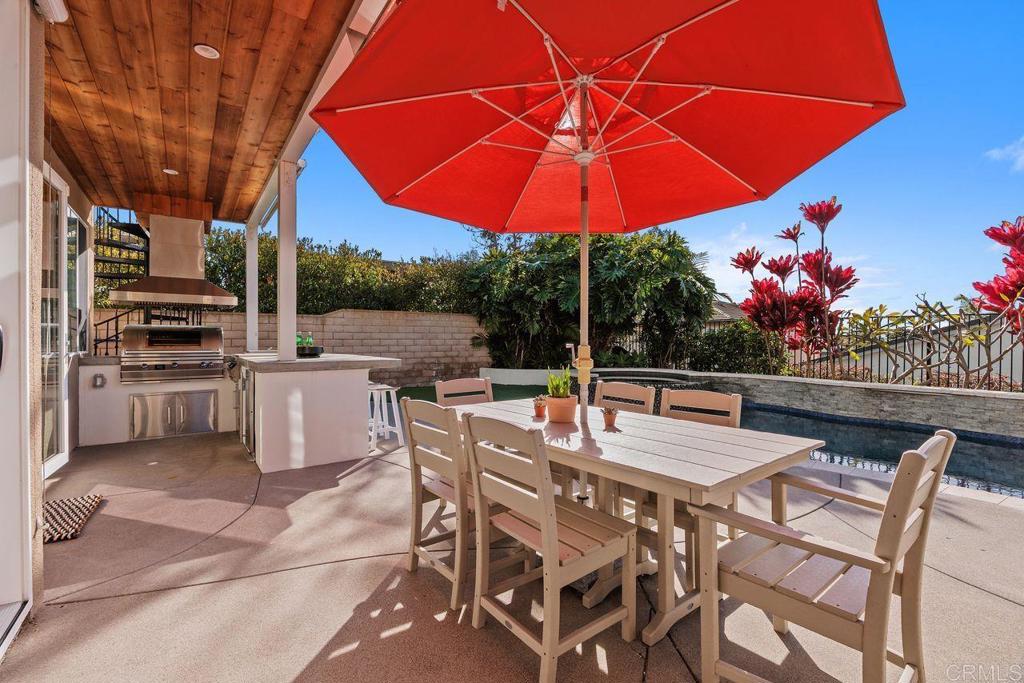 6707 Blue Point Drive Carlsbad, CA 92011 - Photo 8 of 43 a view of a patio with a dining table and chairs under an umbrella