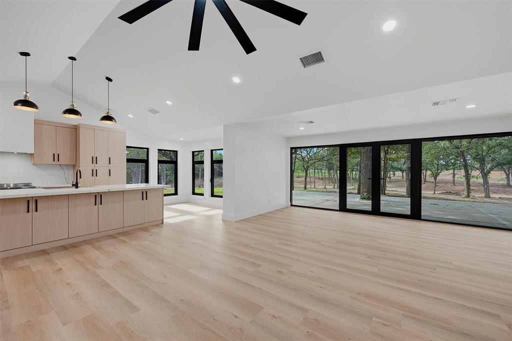 410 Arkansas Road Sadler, TX 76264 - Photo 8 of 40 a large kitchen with kitchen island a large window and a sink