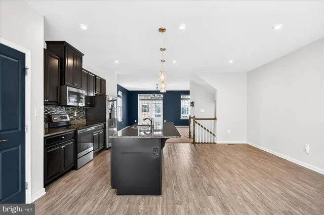 a view of kitchen with refrigerator microwave and stove