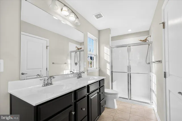 a bathroom with a sink double vanity mirror and a toilet