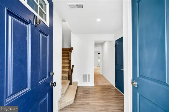a view of a hallway with wooden floor and staircase