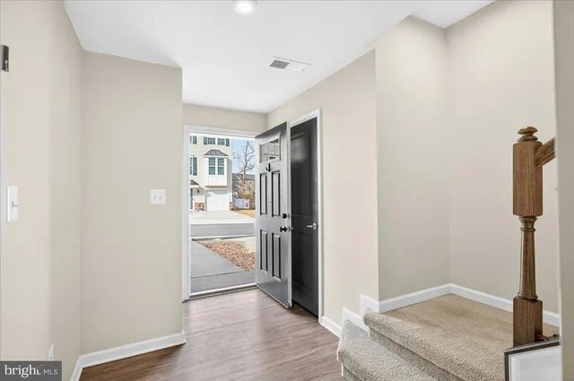 a view of a hallway with wooden floor and closet