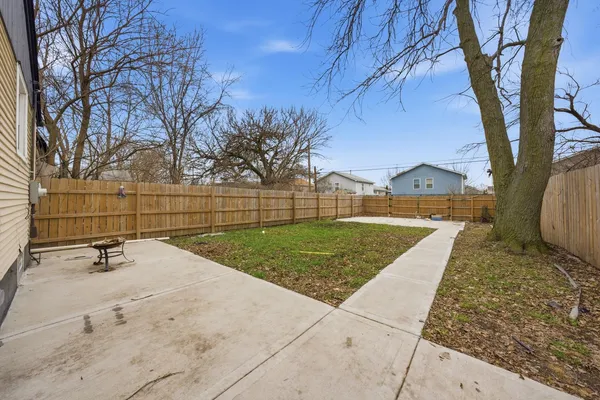a view of backyard with wooden fence