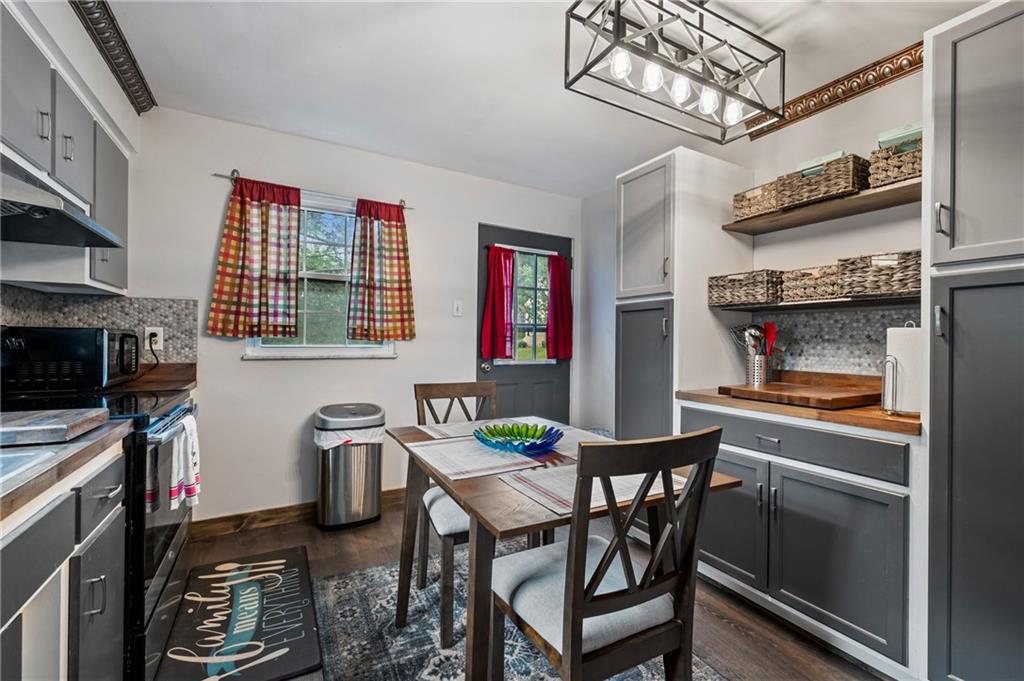 1241 Cochran Road Pittsburgh, PA 15243 - Photo 9 of 30 a kitchen with stainless steel appliances a table and chairs in it