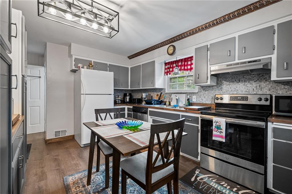 1241 Cochran Road Pittsburgh, PA 15243 - Photo 10 of 30 a kitchen with stainless steel appliances granite countertop a stove a refrigerator and a dining table