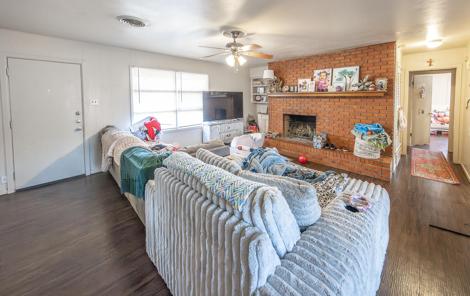 2412 33rd Street Lubbock, TX 79411 - Photo 19 of 34 a living room with furniture a fireplace and a chandelier
