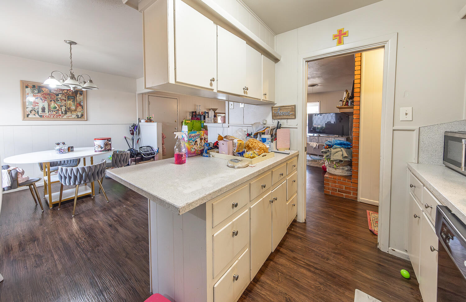 2412 33rd Street Lubbock, TX 79411 - Photo 26 of 34 a kitchen that has a lot of cabinets a sink and wooden floor