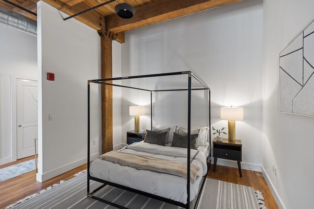 a bedroom with a bed and wooden floor