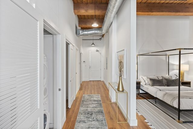 a view of a hallway with wooden floor and staircase