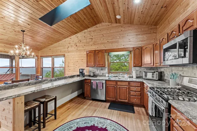 a large kitchen with stainless steel appliances granite countertop a sink and cabinets