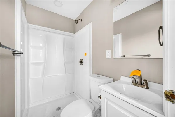 a bathroom with a sink toilet vanity and shower