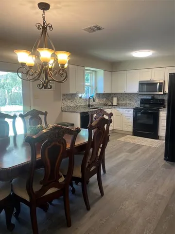 a view of a dining room with furniture and chandelier