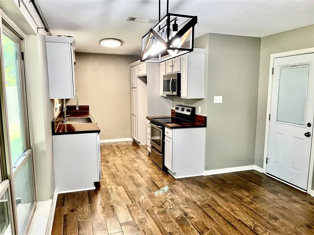 a kitchen with stainless steel appliances a stove a refrigerator and a microwave