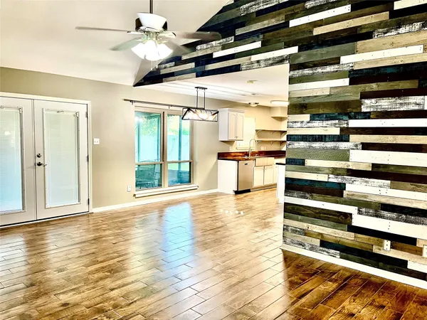 a view of a room with kitchen appliances and wooden floor