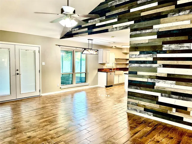 a view of a room with kitchen appliances and wooden floor