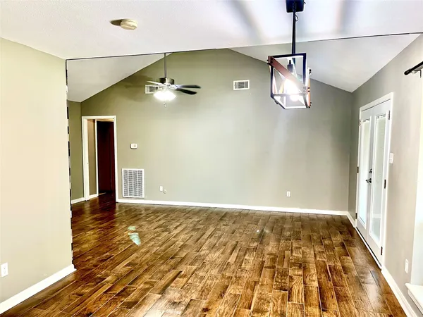 a view of empty room with wooden floor
