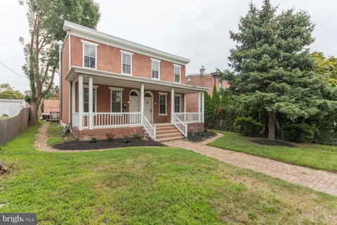 a view of a house with a yard and sitting area