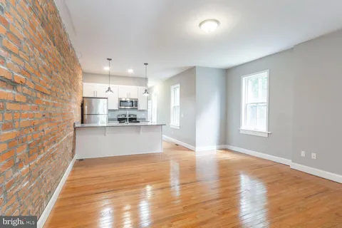 a view of a kitchen with wooden floor and windows