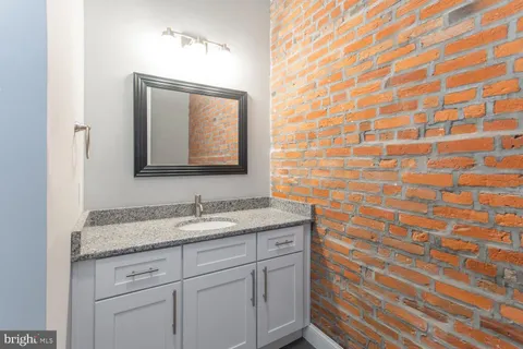 a bathroom with a granite countertop sink and a mirror