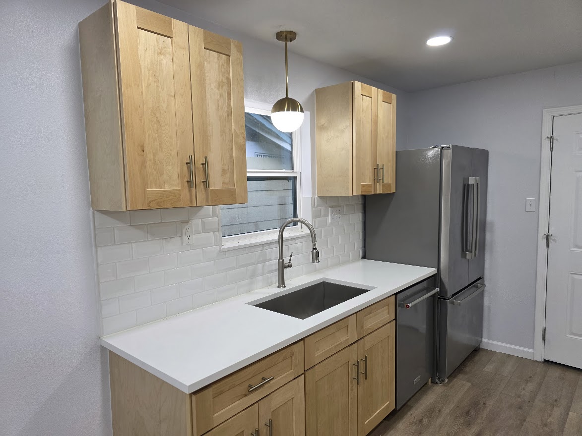 4803 Peach Grove Road Austin, TX 78744 - Photo 15 of 22 a kitchen that has a sink a refrigerator and wooden cabinets