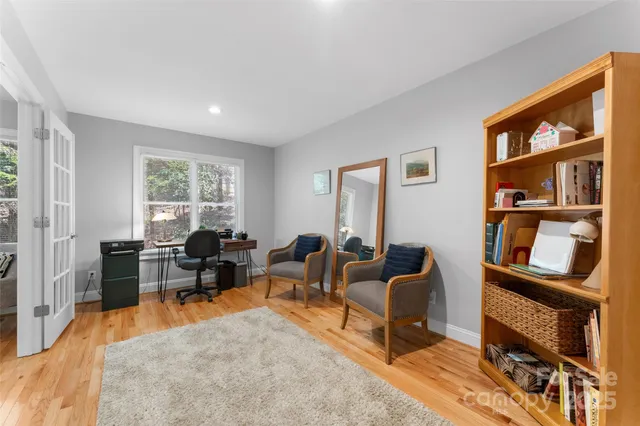 a living room with furniture a bookshelf and a window