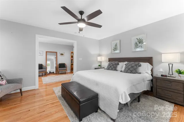 a spacious bedroom with a large bed and a chandelier