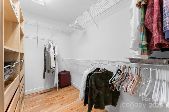 a view of walk in closet with clothes and shoes