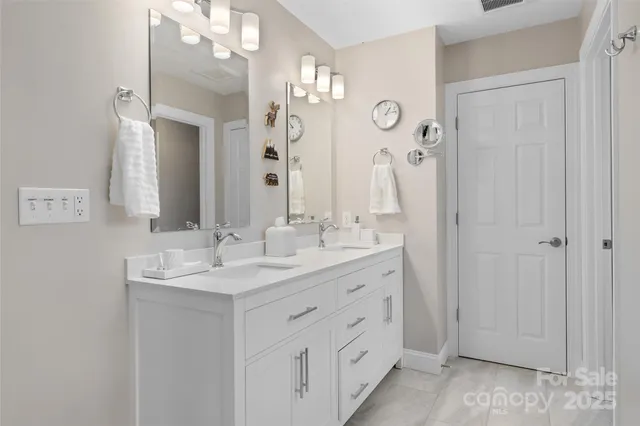a bathroom with a double vanity sink and a mirror