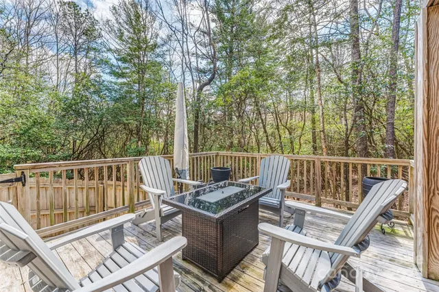 a view of a patio with table and chairs with wooden floor and fence