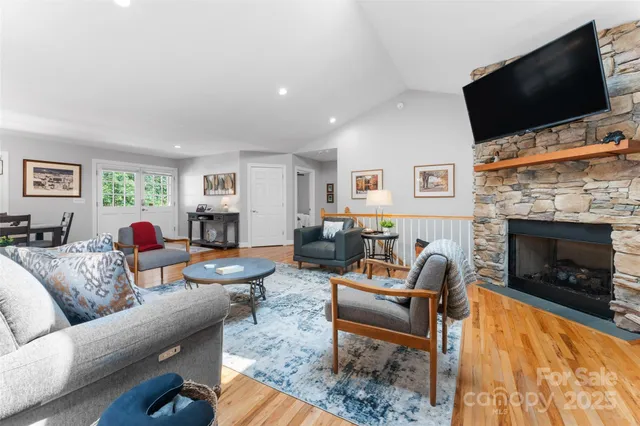 a living room with furniture a flat screen tv and a fireplace