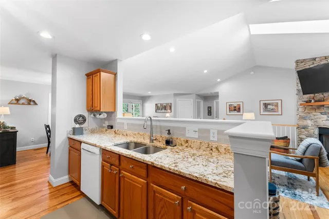 a kitchen with stainless steel appliances granite countertop a sink stove and wooden cabinets